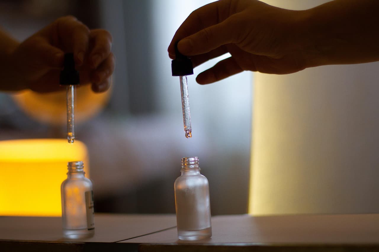 A dropper held over a small glass bottle at the treatment bench